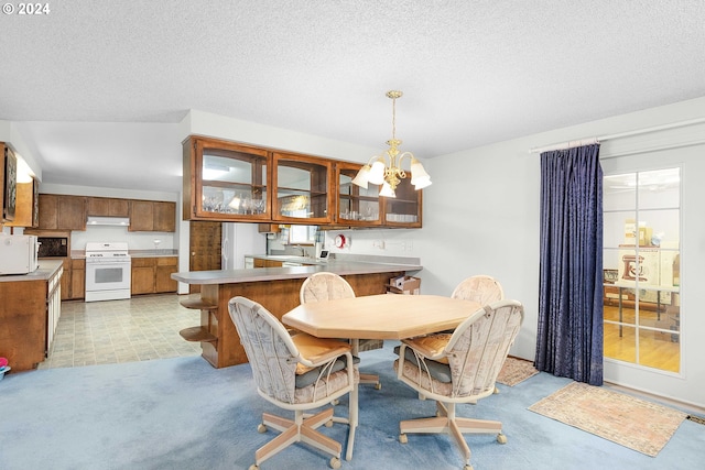 dining room featuring a chandelier, a textured ceiling, and light colored carpet