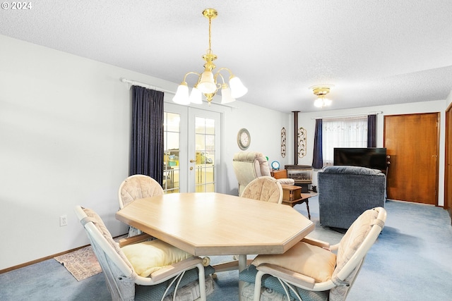 carpeted dining space with french doors, a textured ceiling, and a chandelier