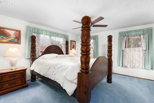 bedroom with ceiling fan, light colored carpet, and a textured ceiling