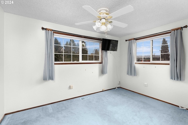 unfurnished room featuring ceiling fan, carpet, and a textured ceiling