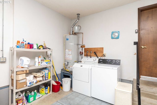 clothes washing area featuring a textured ceiling, washer and clothes dryer, and water heater