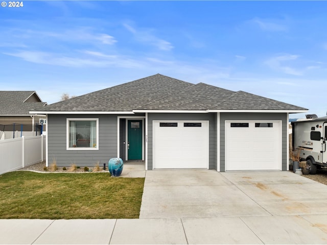 single story home featuring a front yard and a garage