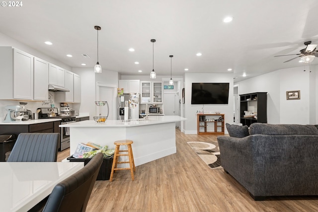 kitchen featuring light wood-type flooring, ceiling fan, appliances with stainless steel finishes, and white cabinetry