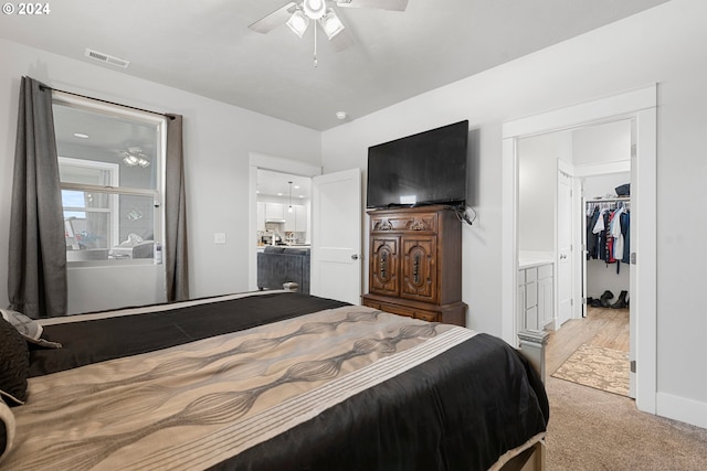 carpeted bedroom with a closet, a walk in closet, and ceiling fan