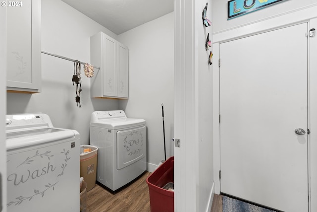 laundry area featuring cabinets, separate washer and dryer, and wood-type flooring