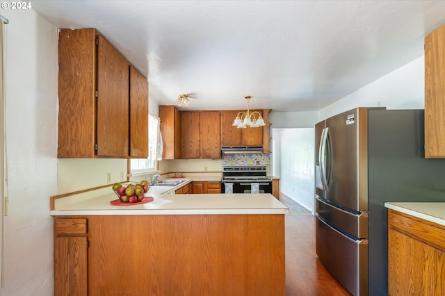 kitchen with kitchen peninsula, decorative light fixtures, black / electric stove, stainless steel refrigerator, and dark hardwood / wood-style flooring