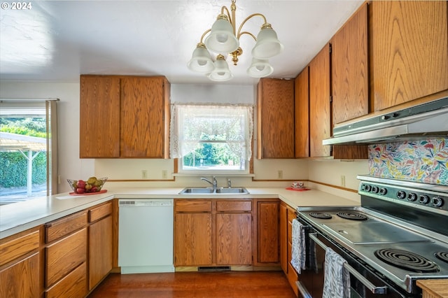 kitchen with white dishwasher, sink, a chandelier, ventilation hood, and black / electric stove