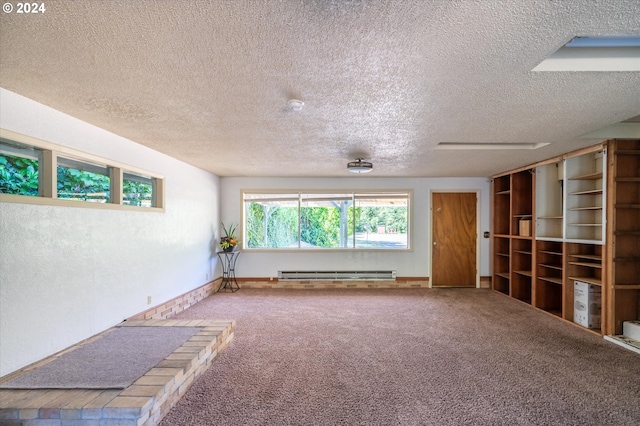 spare room with a textured ceiling, carpet, and a baseboard radiator