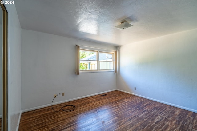 spare room featuring dark hardwood / wood-style flooring