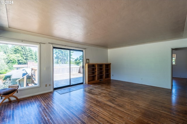 empty room with a textured ceiling and dark hardwood / wood-style flooring