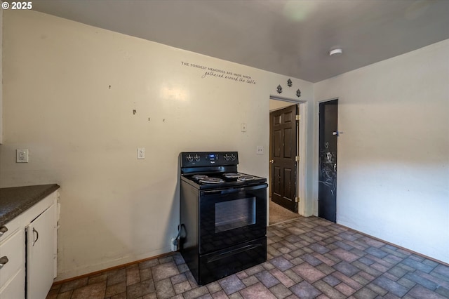 680 NE Laurance St, Myrtle Creek, OR 97457 - kitchen featuring black / electric stove, white cabinetry, brick patterned floors, and dark countertops