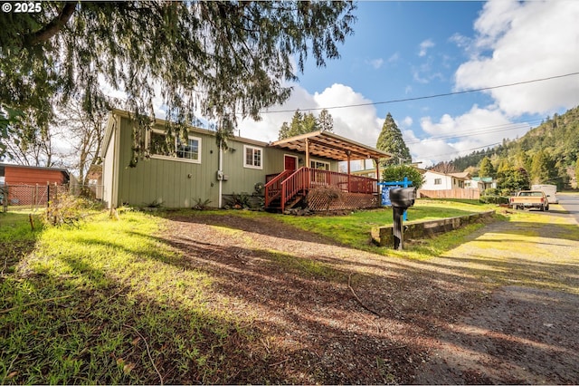 rear view of house with a lawn and a deck