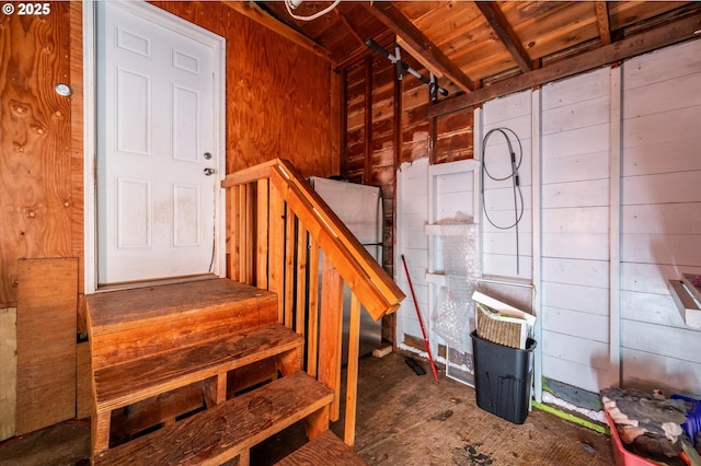 interior space featuring wooden ceiling and wooden walls