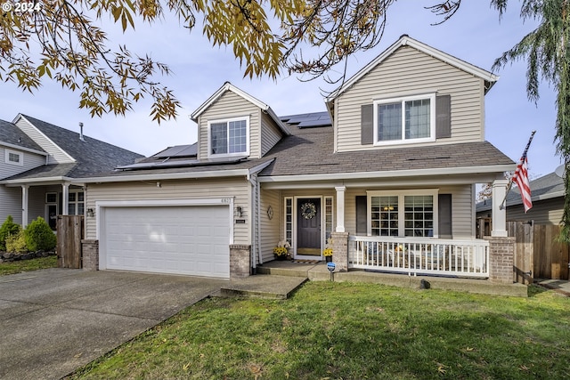 view of front facade featuring a garage, solar panels, covered porch, and a front yard