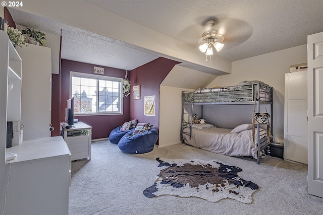 bedroom with ceiling fan, a textured ceiling, and light carpet