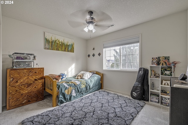 carpeted bedroom featuring a textured ceiling and ceiling fan