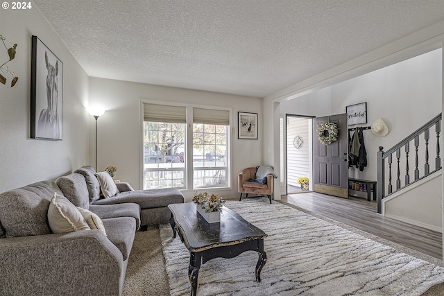 living room with a textured ceiling and light wood-type flooring