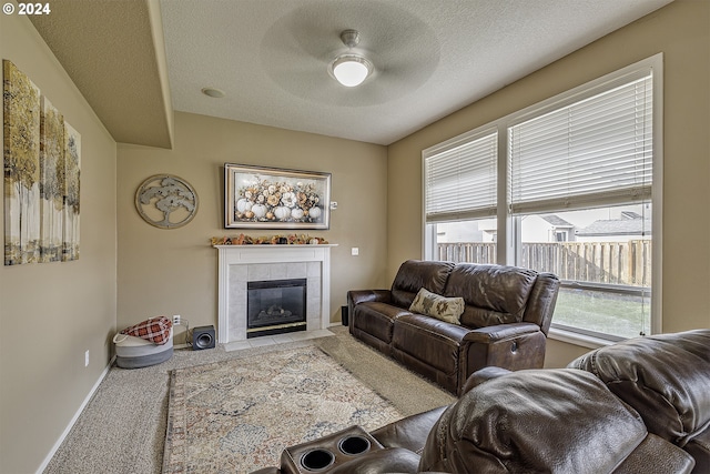 carpeted living room featuring a fireplace, ceiling fan, and a textured ceiling