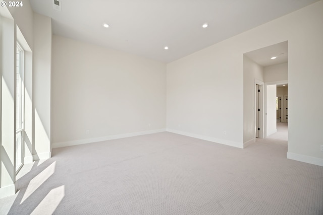 spare room with light carpet, visible vents, baseboards, and recessed lighting