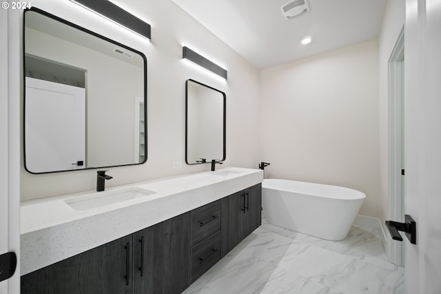 bathroom featuring marble finish floor, visible vents, a sink, and a freestanding bath