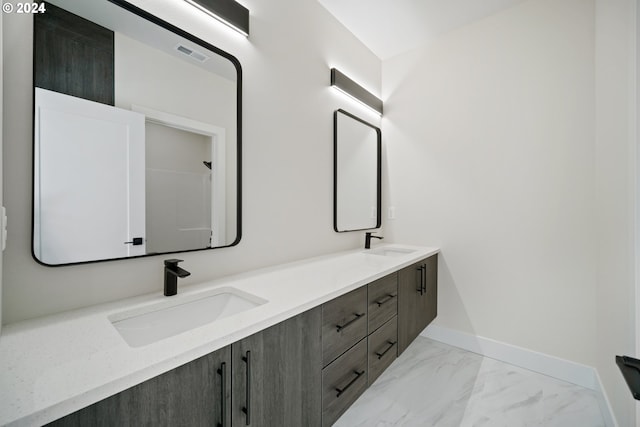 full bath with marble finish floor, a sink, visible vents, and baseboards