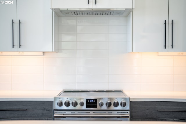 kitchen with tasteful backsplash, light countertops, electric range, gray cabinetry, and under cabinet range hood