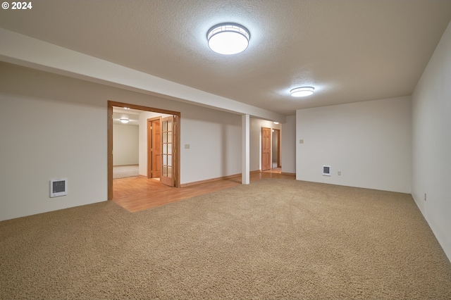 carpeted empty room featuring visible vents and a textured ceiling