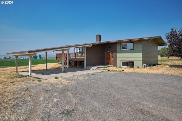 view of front of property with a chimney, a deck, and brick siding