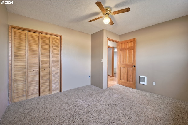 unfurnished bedroom featuring a closet, visible vents, a ceiling fan, carpet flooring, and a textured ceiling