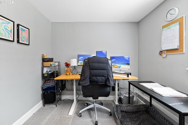 carpeted office space featuring a textured ceiling