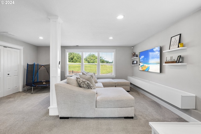 living room featuring ornate columns and light carpet