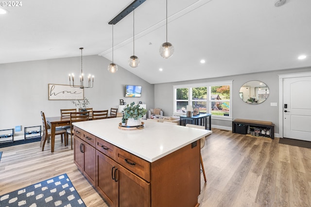 kitchen with an inviting chandelier, light wood-type flooring, pendant lighting, lofted ceiling, and a center island