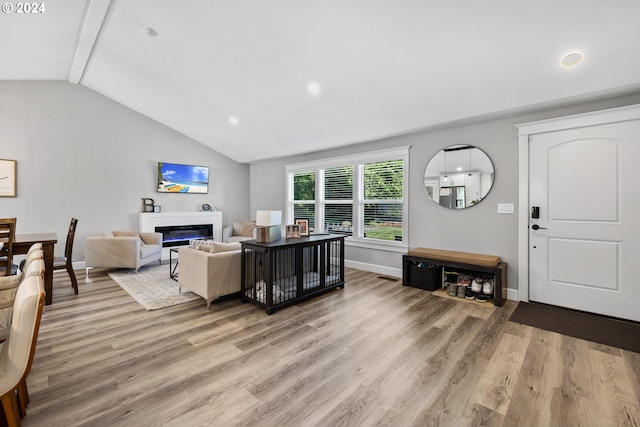 living room featuring vaulted ceiling with beams and hardwood / wood-style floors