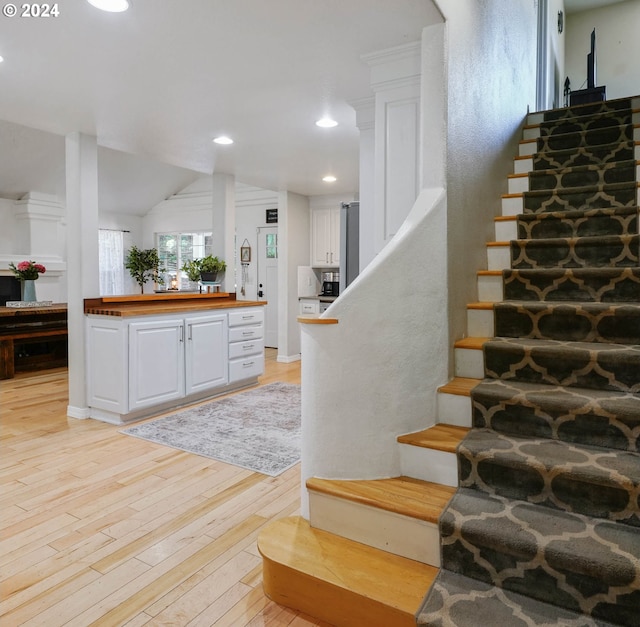 staircase featuring hardwood / wood-style flooring and vaulted ceiling