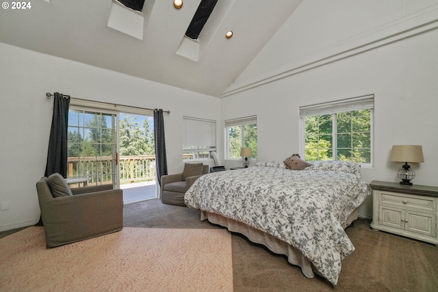 carpeted bedroom with access to exterior, high vaulted ceiling, and a skylight