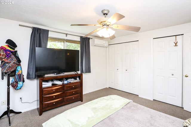 bedroom featuring ceiling fan, carpet floors, and a wall mounted air conditioner