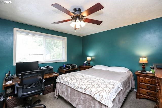 bedroom featuring ceiling fan, a textured ceiling, and carpet