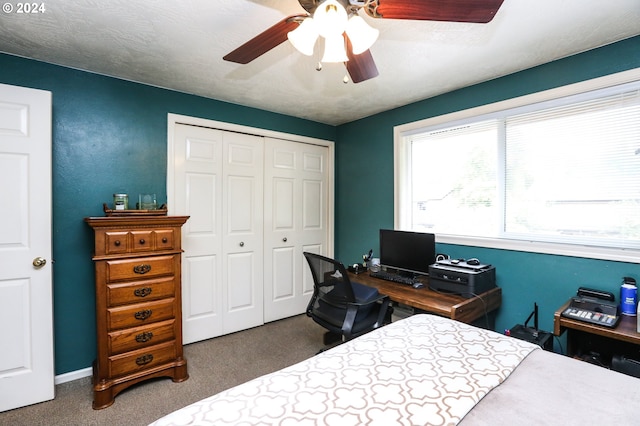 bedroom with dark carpet, a closet, ceiling fan, and a textured ceiling