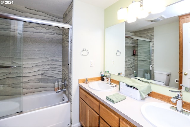 full bathroom featuring shower / bath combination with glass door, vanity, and toilet