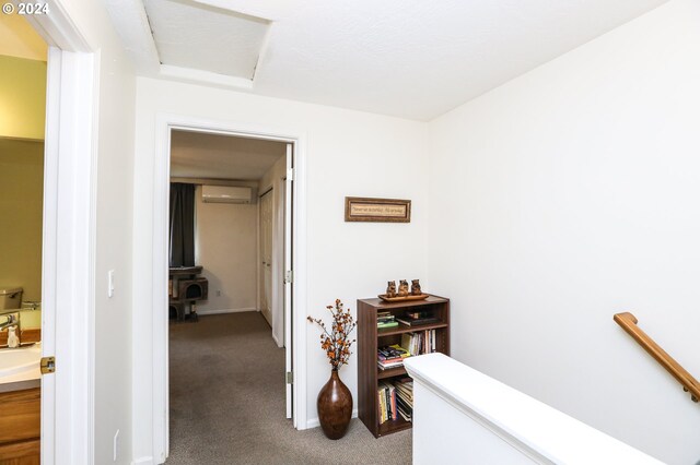 hallway featuring a wall unit AC and carpet floors