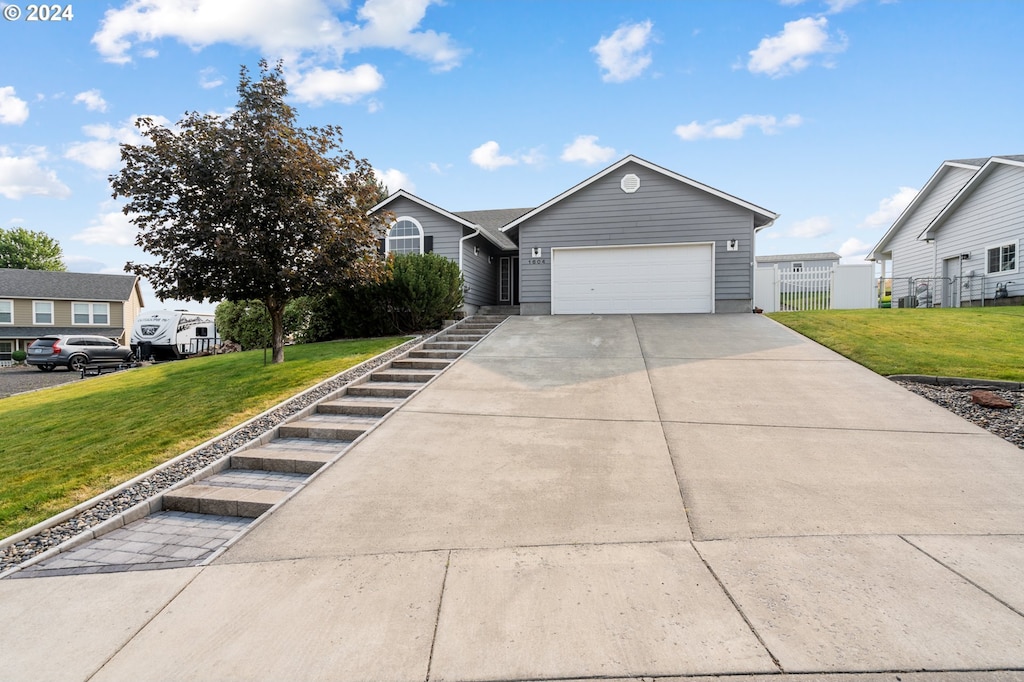 view of front of house with a garage and a front lawn