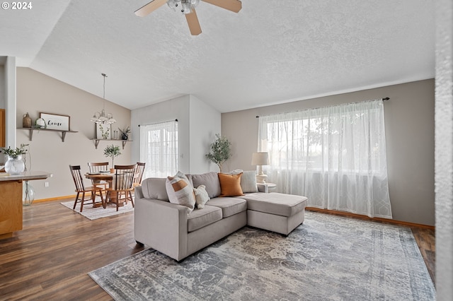 living room featuring hardwood / wood-style flooring, lofted ceiling, a healthy amount of sunlight, and a textured ceiling