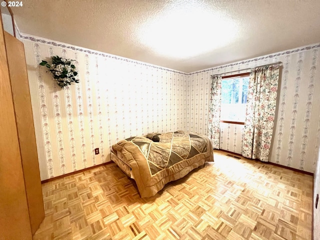 bedroom featuring a textured ceiling and light parquet floors