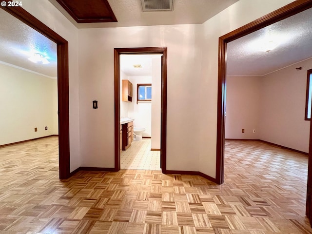 hallway featuring light parquet floors and ornamental molding