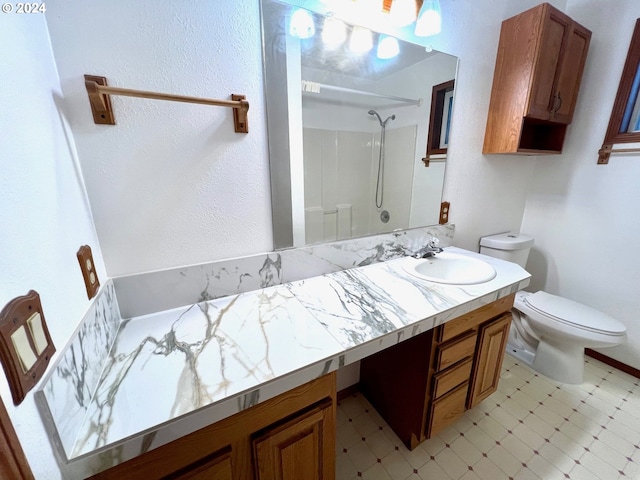 bathroom featuring toilet, vanity, and walk in shower