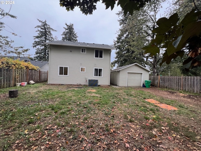 back of house with an outbuilding, a garage, central AC, and a lawn