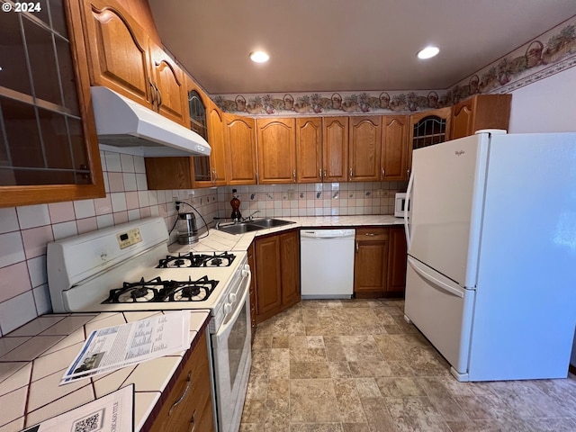 kitchen with tasteful backsplash, sink, and white appliances