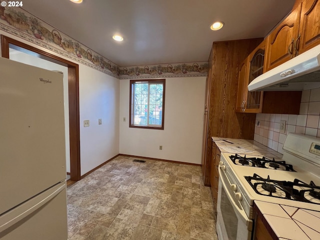 kitchen with white appliances, tile countertops, and tasteful backsplash