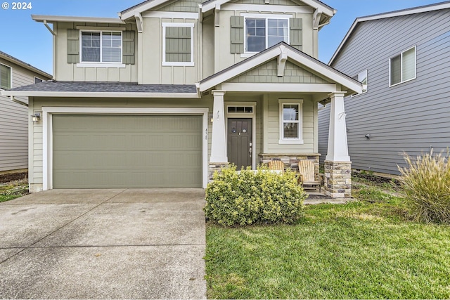 craftsman house with a garage, covered porch, board and batten siding, and concrete driveway