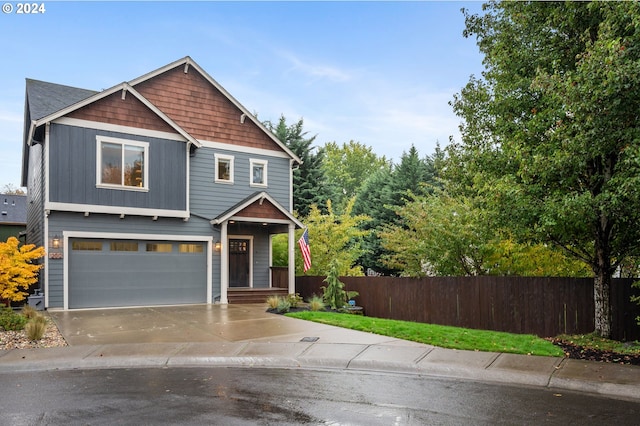 craftsman-style house with a garage, concrete driveway, and fence